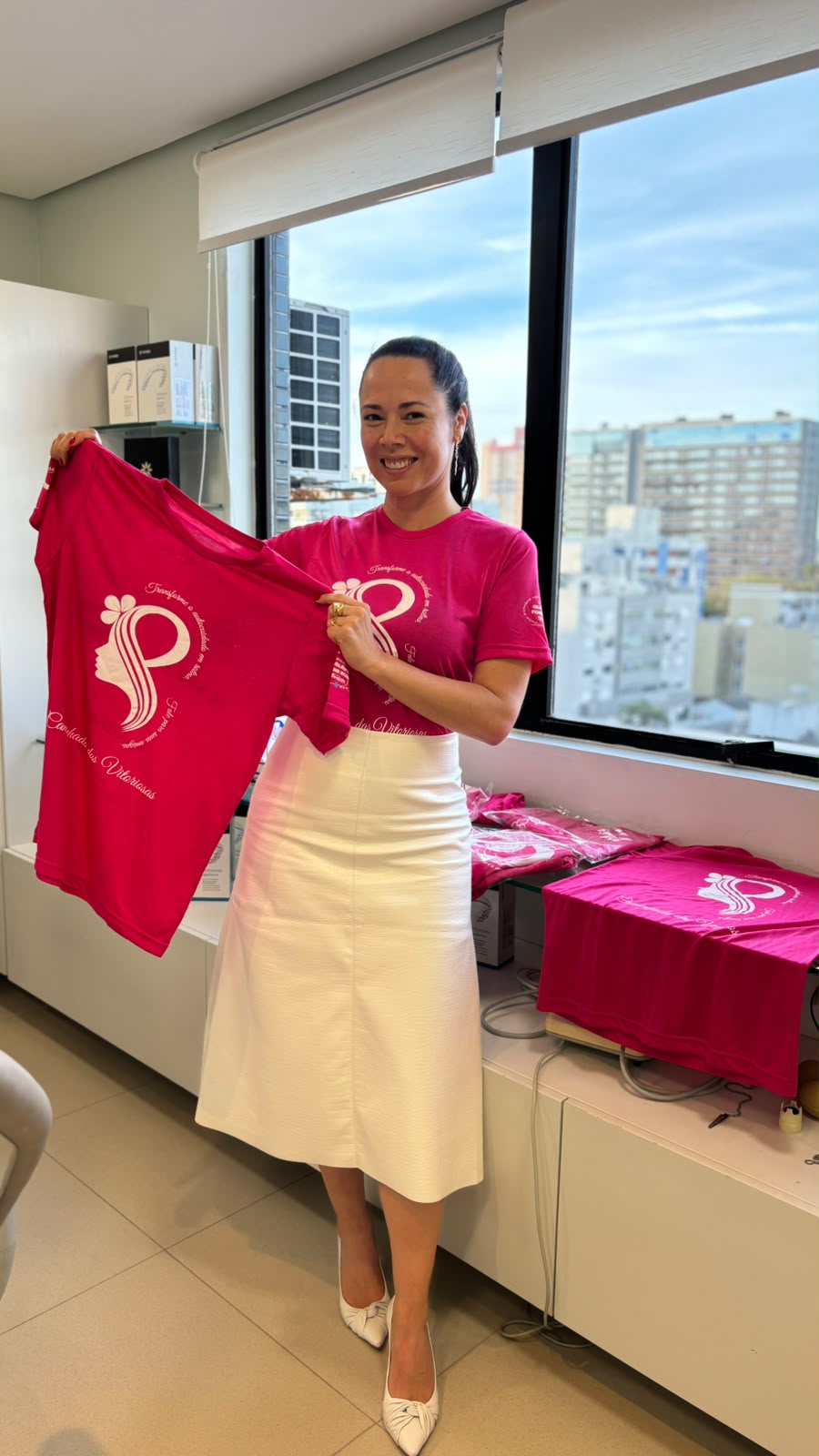 Dra. Fernanda com as camisetas rosa do IMAMA na clínica