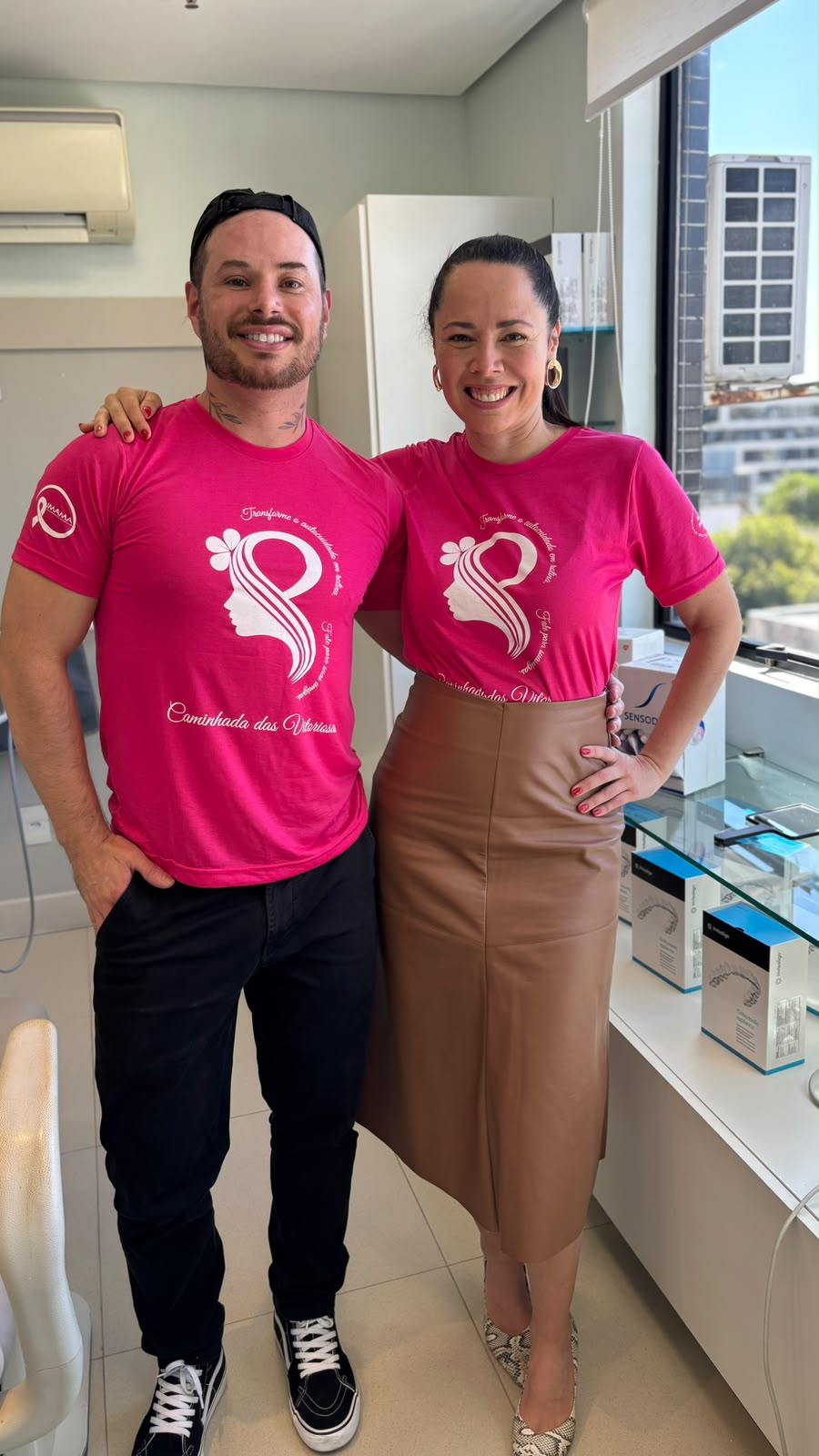 Dra. Fernanda e participante sorrindo com as camisetas rosa