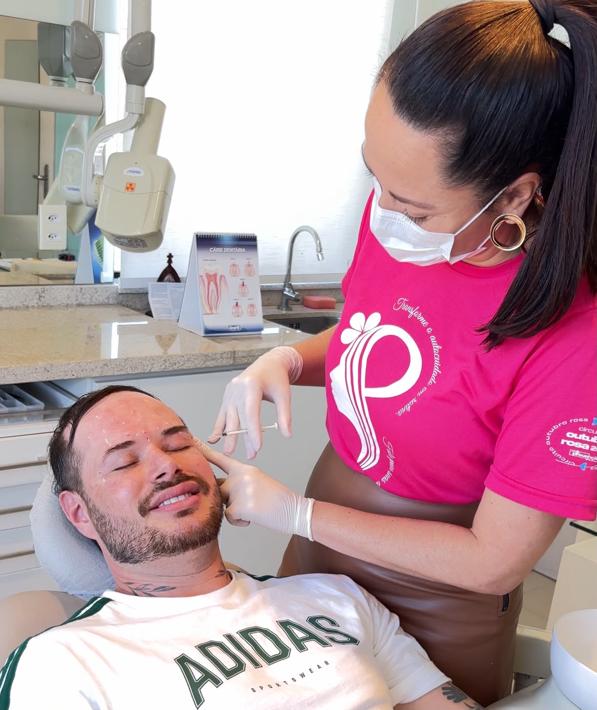 Dra. Fernanda com camiseta rosa do IMAMA em atendimento a Tiago