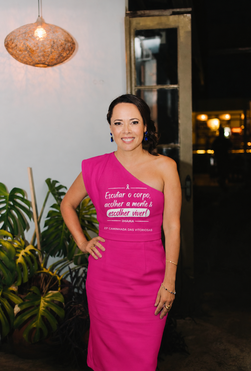 Dra. Fernanda Beltrão sorrindo, vestida de rosa com a mensagem do IMAMA