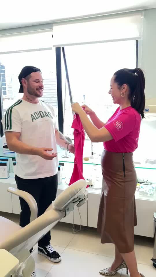 Participante sorrindo com a camiseta da campanha na clínica