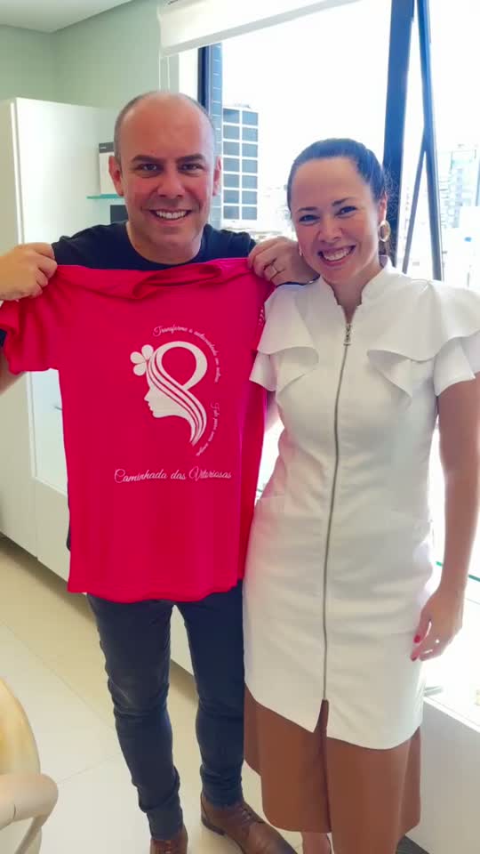 Dra. Fernanda e participante sorrindo com a camiseta do IMAMA